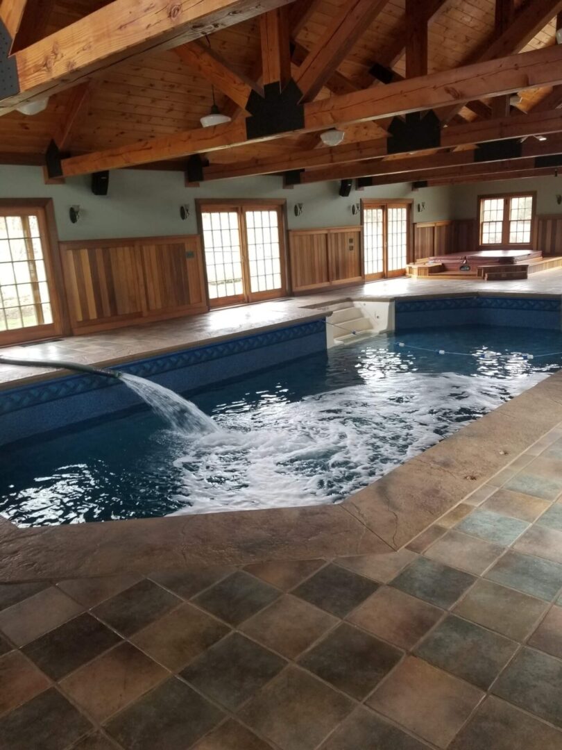 A large indoor swimming pool with water falling from the ceiling.