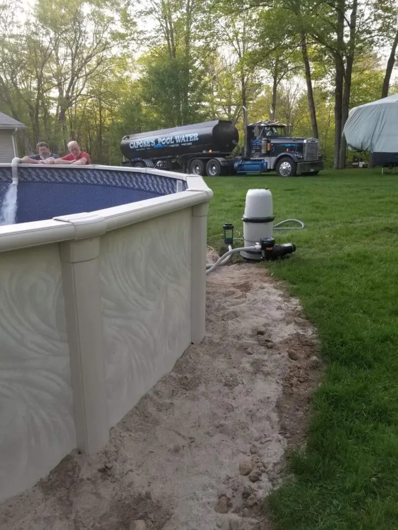 A pool that is in the grass near some trees.