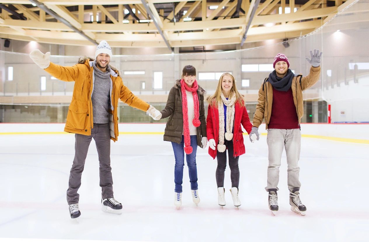 A group of people standing on top of an ice rink.